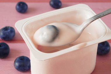 Tahta arka planda taze yoğurt, çilek ve yabanmersini. Sağlıklı Kahvaltı Konsepti. Yakın çekim