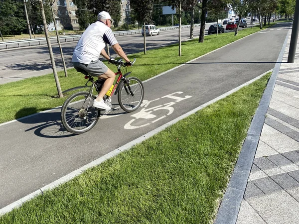 Bike Lane in city near car road, Bicyclist crossing bike lane, outdoors