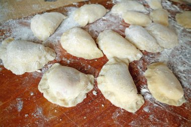 Ev yapımı mantı, ravioli veya sebzeli pelmeni yapma süreci. Tahta tahtada raviyolis pişirmeye hazır olun.