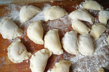 Ev yapımı mantı, ravioli veya sebzeli pelmeni yapma süreci. Tahta tahtada raviyolis pişirmeye hazır olun.