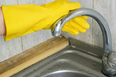 Ev masasını temizlemek, mutfak masasının yüzeyini dezenfektan sprey şişesiyle temizlemek sünger ve eldiven ile yüzeyi yıkamak. Yakın çekim.