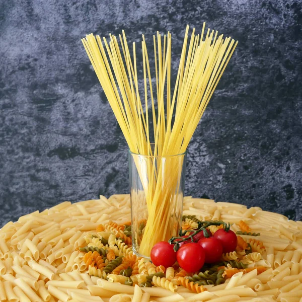 Çeşitli makarna çeşitleri, çiğ makarna seti ve domates, set, yakın çekim