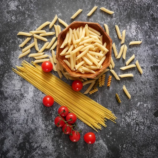 Çeşitli makarna çeşitleri, çiğ makarna seti ve domates, set, yakın çekim