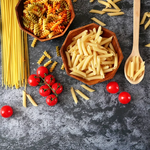 Çeşitli makarna çeşitleri, çiğ makarna seti ve domates, set, yakın çekim