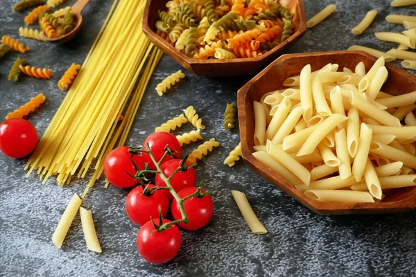 Çeşitli makarna çeşitleri, çiğ makarna seti ve domates, set, yakın çekim