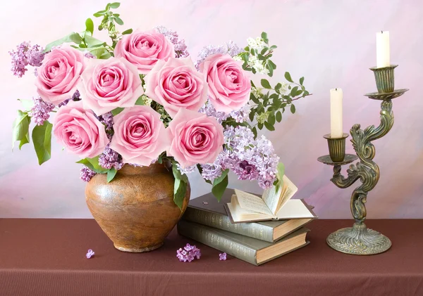 Bodegón con rosas y flores lila, libros y candelabros sobre fondo artístico —  Fotos de Stock