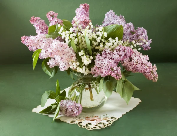 Masih hidup dengan bunga ungu dan bunga bakung dari lembah dalam vas terisolasi pada latar belakang artistik — Stok Foto
