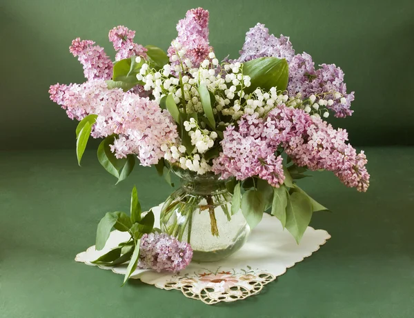 Natureza morta com flores lilás e lírio do vale em vaso isolado no fundo artístico — Fotografia de Stock