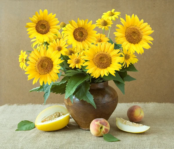 Stillleben mit Sonnenblumen und Früchten auf künstlerischem Hintergrund — Stockfoto