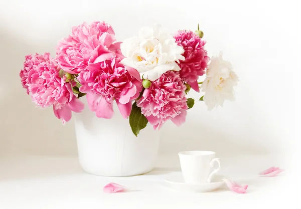 Nature morte artistique avec pivoines et tasse de café et pétales — Photo