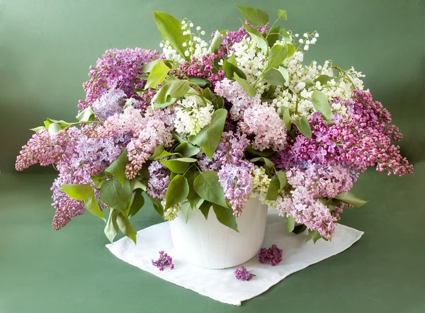 Fremdeles liv med syrinblomster i vase på kunstnerisk bakgrunn – stockfoto