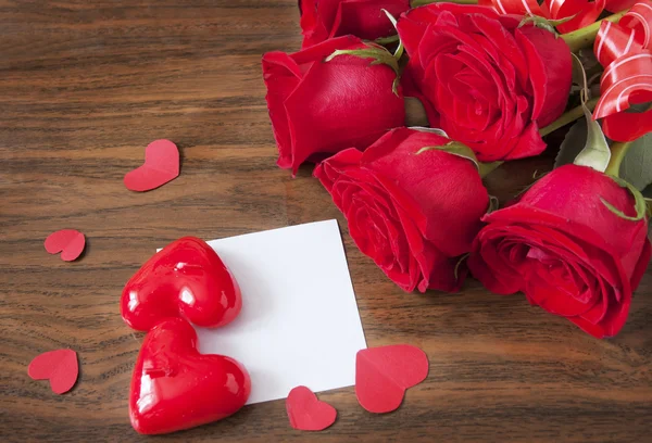 Rose flowers and heart symbol bunch on wooden desk with white blank. Valentine's day concept. Love concept — Stock Photo, Image