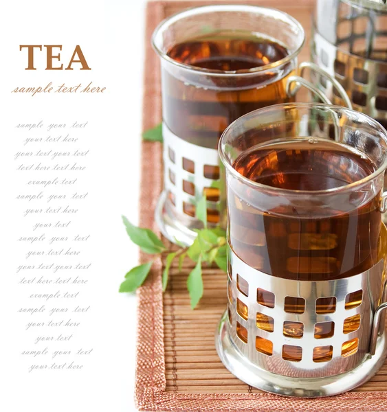 Healthy Tea (still life with tea glasses and green leaves on bamboo mat isolated on white background with sample text) — Stock Photo, Image