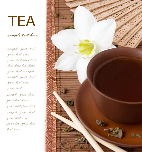 Πρωινό τσάι (νεκρή φύση με ένα φλυτζάνι τσάι και τα φύλλα τσαγιού που απομονώνονται σε λευκό φόντο με δείγμα κειμένου) — Φωτογραφία Αρχείου