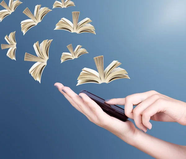 Hand holding modern mobile phone and open books flying away. Education concept — Stock Photo, Image