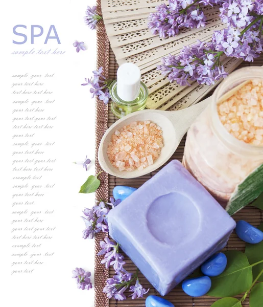 Lilac spa (fresh lilac flowers,spa salt, zen stones, Herbal massage balls, towel) on a wooden bord (with easy removable text) — Stock Photo, Image