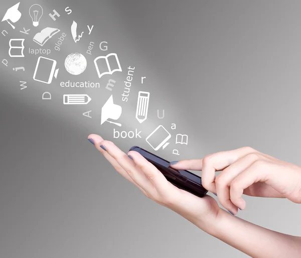 Akıllı cep telefonu ve uçup eğitim kavramı eğitim sembolleri tutan el