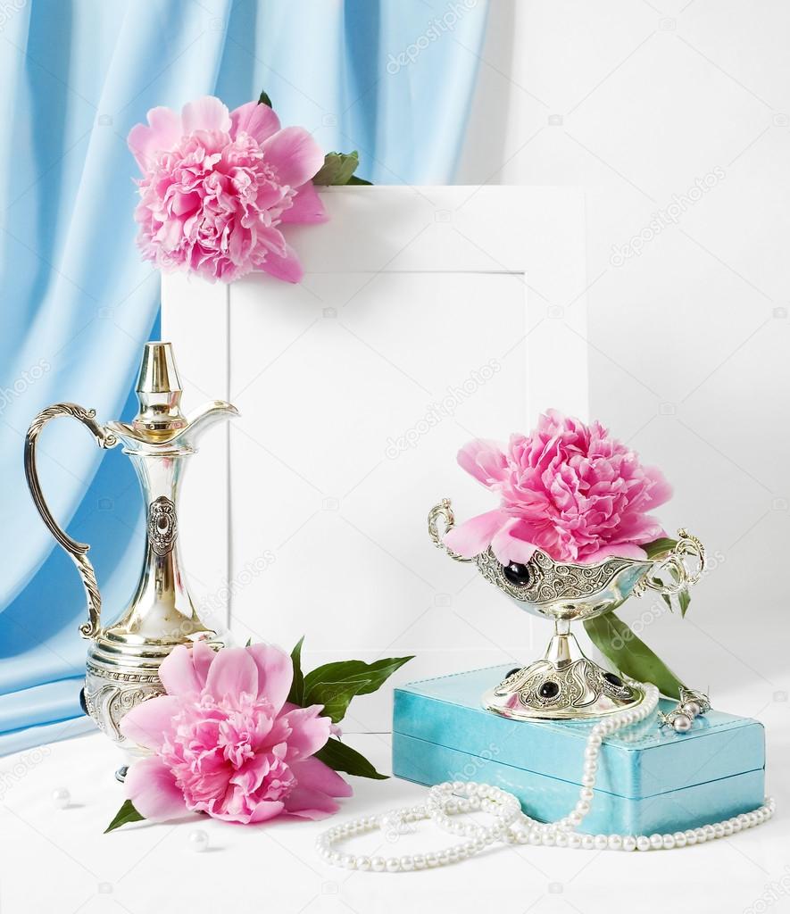 Still life with pink peonies, antique silver tableware, jewelry and frame