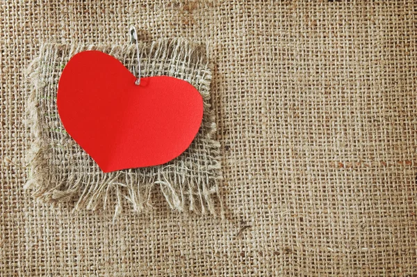 Día de San Valentín (corazón rojo con pin sobre fondo de lona hessiana . ) — Foto de Stock