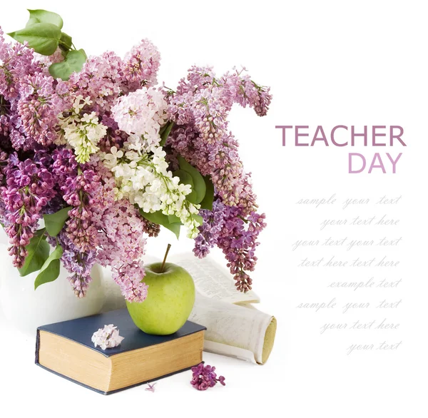 Öğretmen günü (Lila çiçek, kitap, apple ve örnek metin beyaz zemin üzerine izole harita çok büyük grup ile natürmort) — Stok fotoğraf