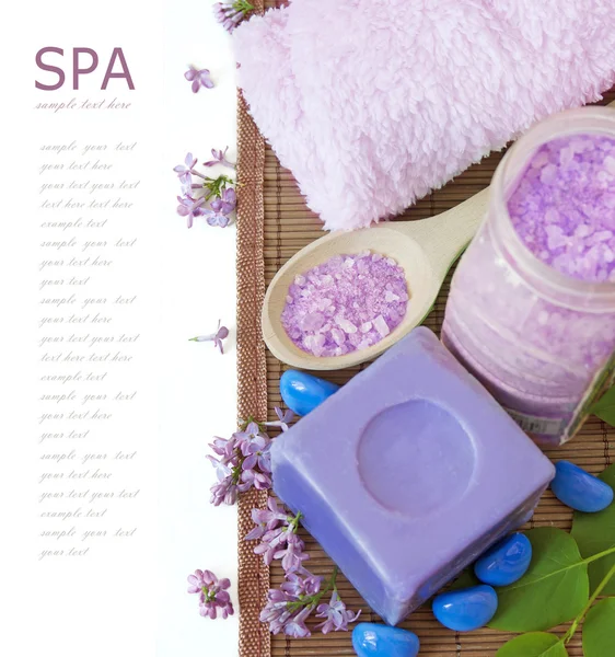 Lilac spa (fresh lilac flowers,spa salt, zen stones, Herbal massage balls, towel) on a wooden bord (with easy removable text) — Stock Photo, Image