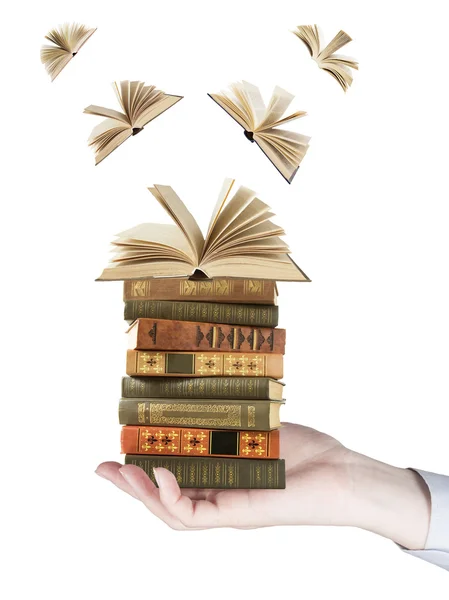 Hand holding book stack and books flying away isolated on white background. Education concept — Stock Photo, Image