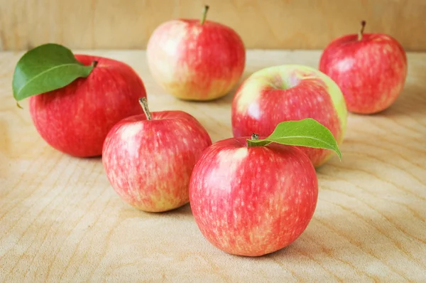 Красные яблоки в корзине на деревянном фоне — стоковое фото