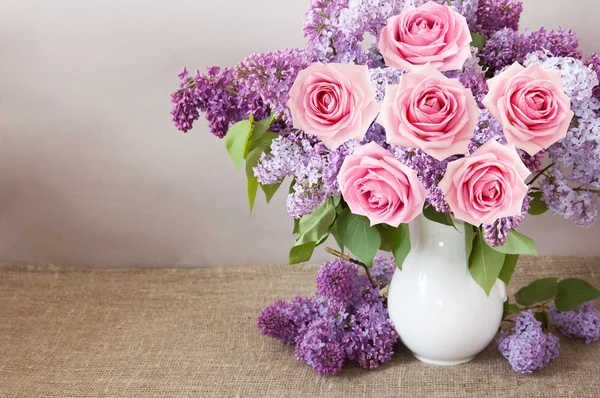 Bodegón con rosas y flores lila sobre fondo artístico — Foto de Stock