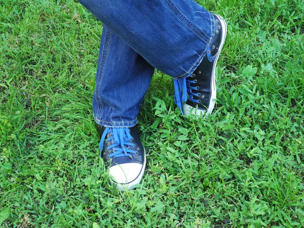 Moderna sneakers på gräs. Jeans gymnastikskor. Sport skor koncept. — Stockfoto