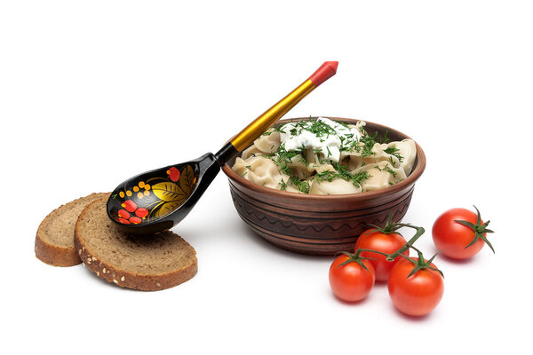 Русские пельмени со сметаной в глиняной тарелке на белом берегу
