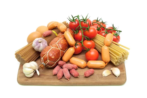 Pasta, verduras y embutidos en una tabla de cortar —  Fotos de Stock