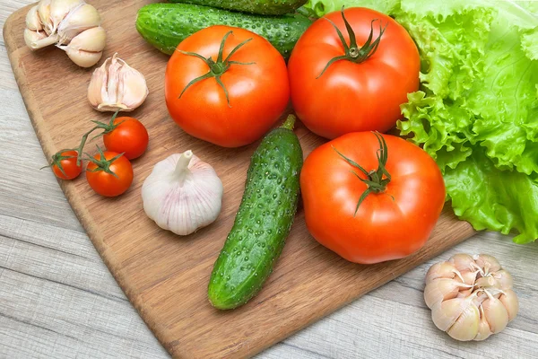 Verdure fresche su un tagliere su un tavolo di legno — Foto Stock