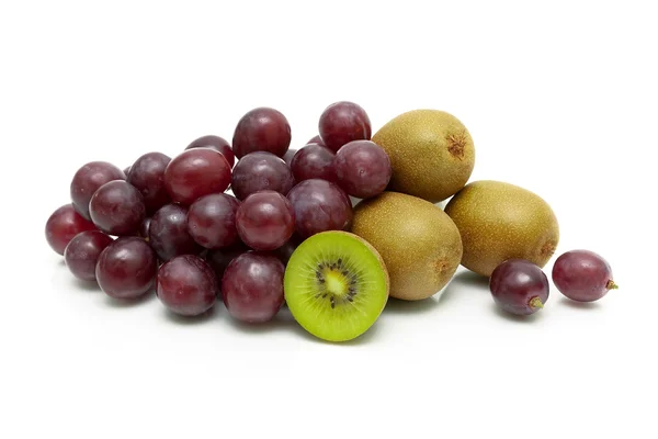 Rijpe kiwi en donkere druiven op een witte achtergrond — Stockfoto