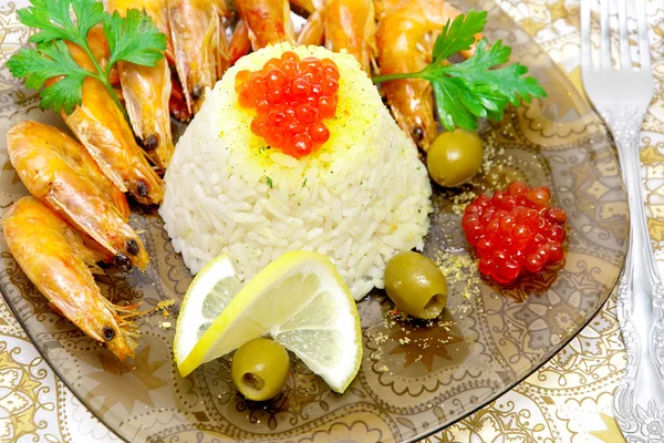 Steamed rice with red caviar, shrimp, lemon and olives close-up — Stock Photo, Image
