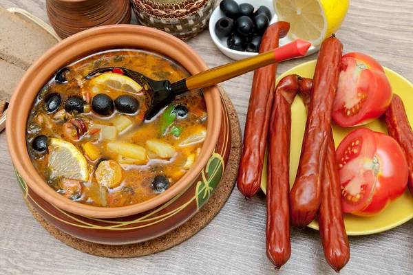 Appetizing dish of russian hodgepodge soup in ceramic pot — Stock Photo, Image