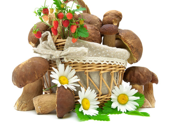 Корзина с грибами и клубникой крупным планом на белой бэкгру
