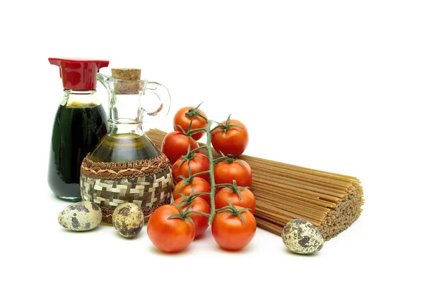Cherry tomatoes, pasta, quail eggs, olive oil and soy sauce on w — Stock Photo, Image