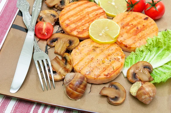 Appetizing fried medallions of salmon, stuffed snails with mushr — Stock Photo, Image