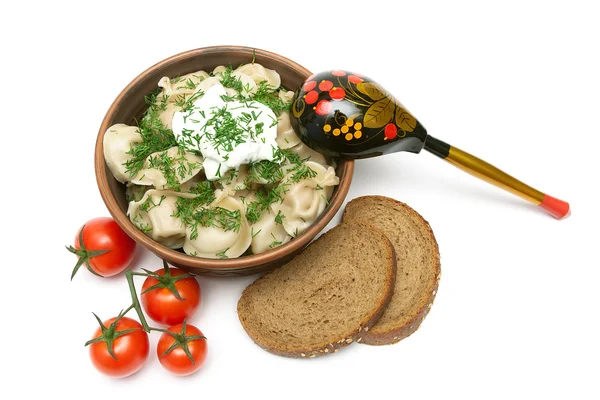 Dumplings with meat in an earthenware bowl, bread and tomatoes o — Stock Photo, Image