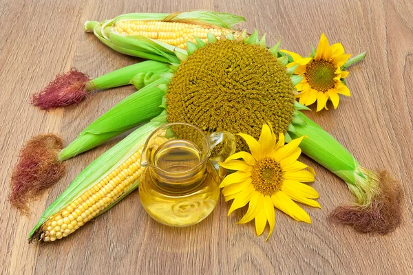 Tournesols mûrs, maïs et huile dans un bocal en verre gros plan sur bois — Photo