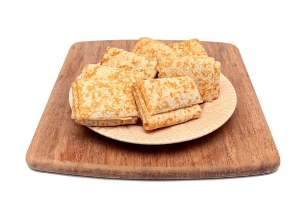 Panqueques rusos en un plato en una tabla de cortar aislado en blanco — Foto de Stock