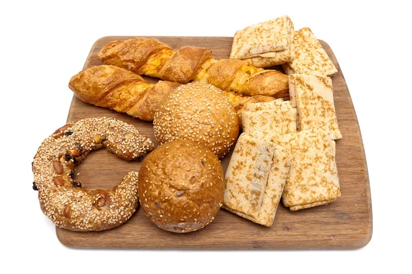 Baked goods and pancakes on a cutting board isolated on white ba — Stock Photo, Image