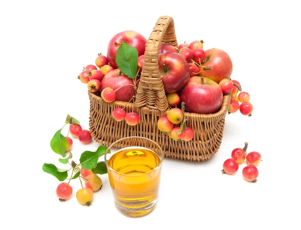 Ripe apples in a wicker basket and a glass of juice isolated on — Stock Photo, Image