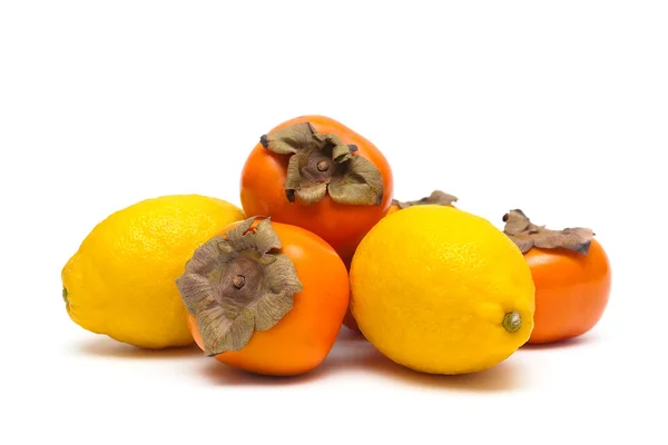 Zitronen und Kaki isoliert auf weißem Hintergrund Nahaufnahme — Stockfoto