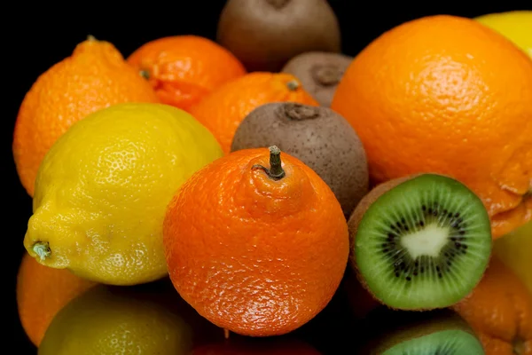 Mandarine et autres fruits gros plan sur fond noir — Photo