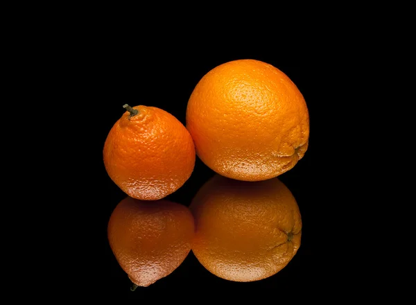 Reife Orange und Mandarine auf schwarzem Hintergrund mit Reflexion — Stockfoto