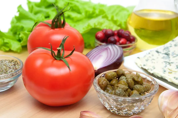 Tomates maduros y otros alimentos en una tabla de cortar — Foto de Stock