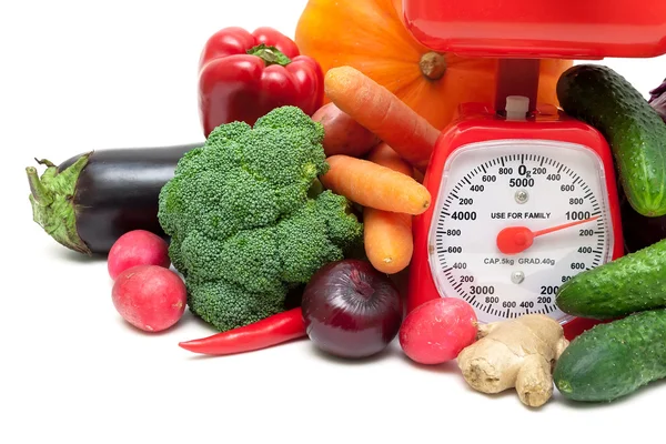 Kitchen scale and vegetables on a white background — Stock Photo, Image