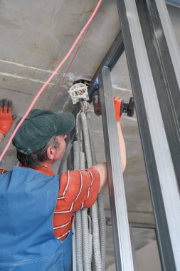 Bir işçi alçıpandan duvar yapar.