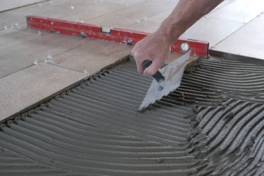 İşçi inşaat alanına seramik fayanslar koyar.